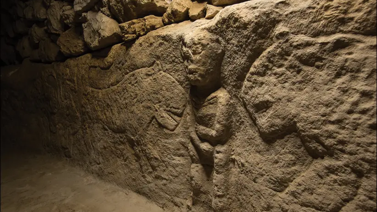 ancient carving man holding penis